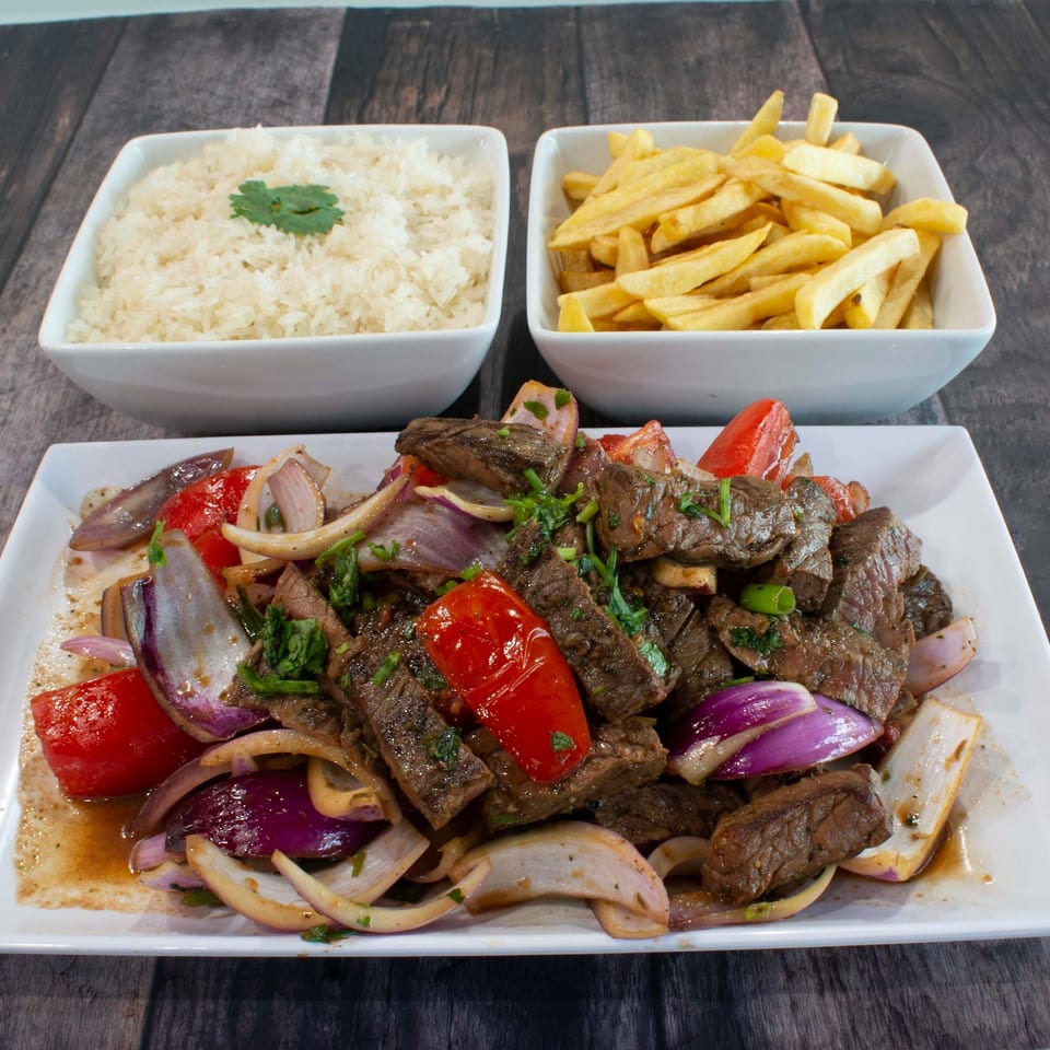 Nazca Express's Lomo Saltado with steak, red onions, tomatoes, cilantro, served with rice and fries.